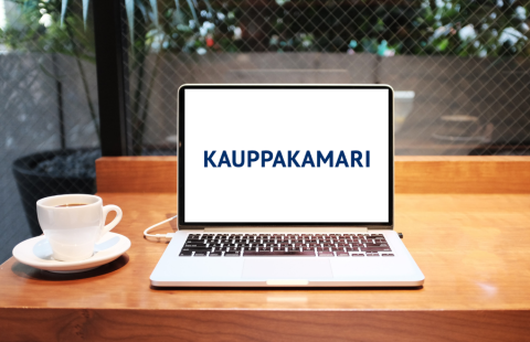 Pöydällä kahvikuppi ja avoin läppäri, jonka ruudulla on kauppakamarin logo.