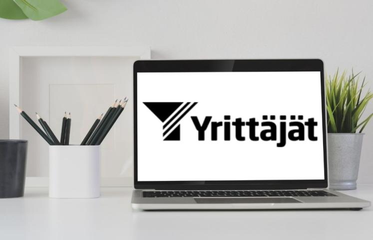 Yrittäjien logo avoimen läppärin ruudulla.