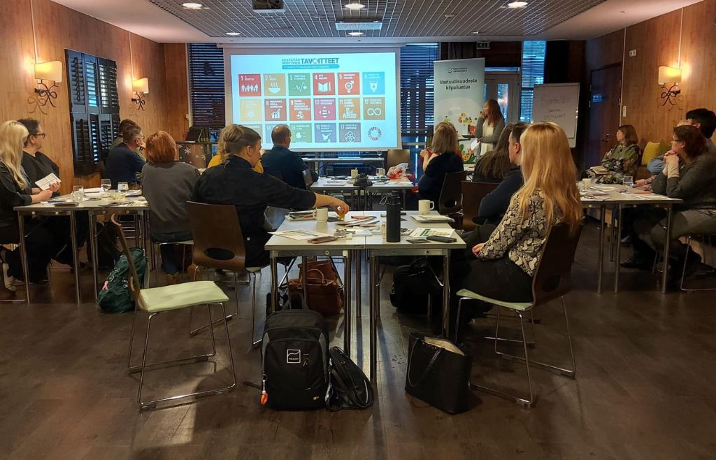 Valmennuksen osallistujat kuuntelemassa kouluttajan esitystä kestävän kehityksen tavoitteista.