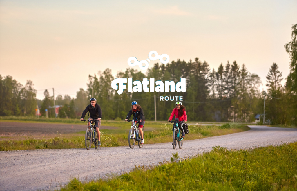 Kolme henkilöä pyöräilemässä tietä pitkin auringonlaskun aikaan.